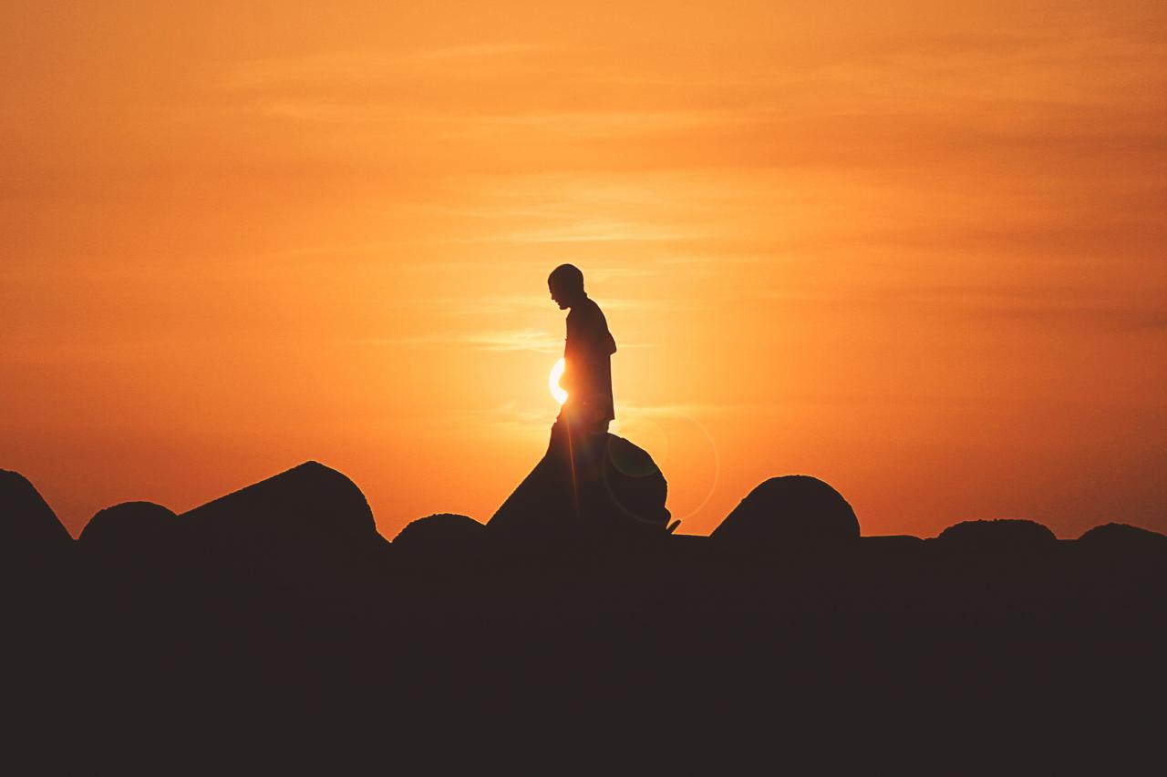 person walking alone during sunset