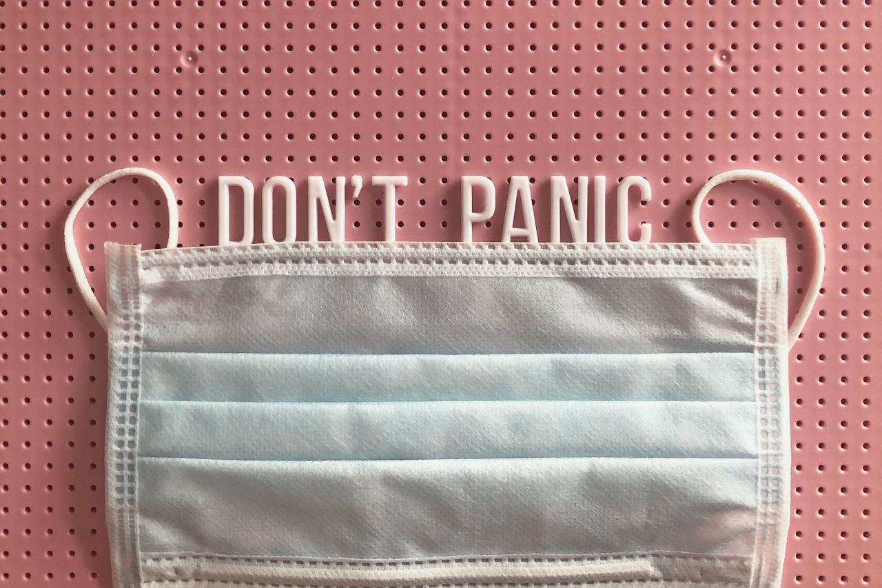 a face mask with the words "don't panic" above it