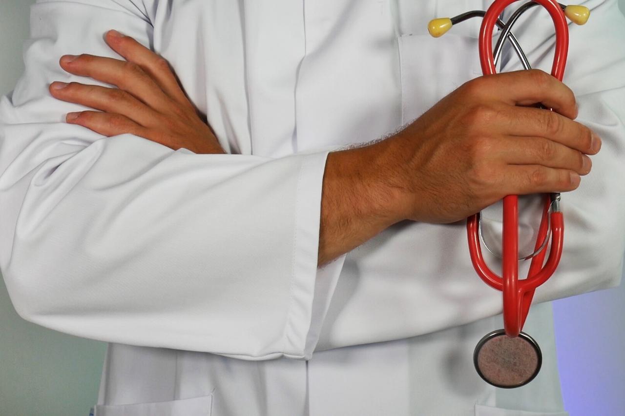 doctor with arms crossed, holding a stethoscope