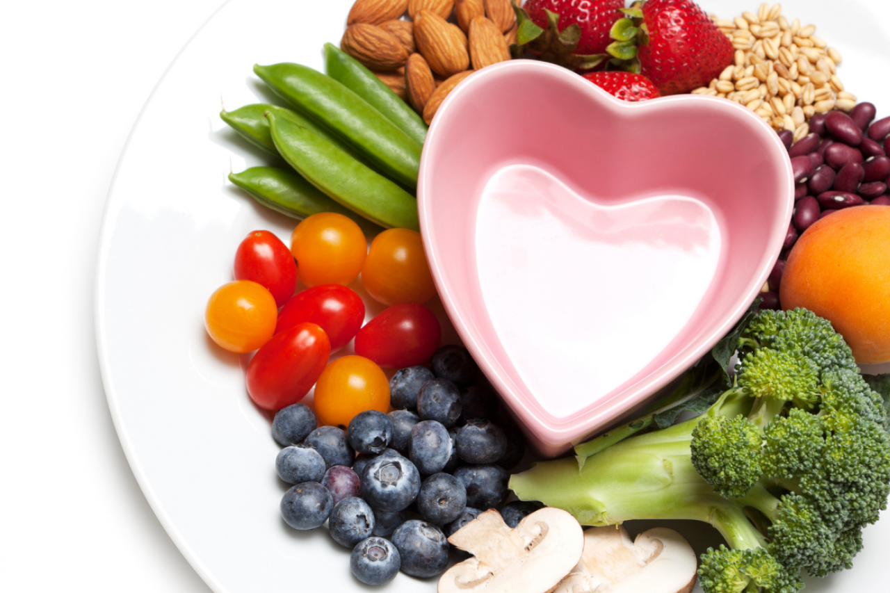 fruits, vegetables, grains, and protein on a plate around a heart-shaped bowl