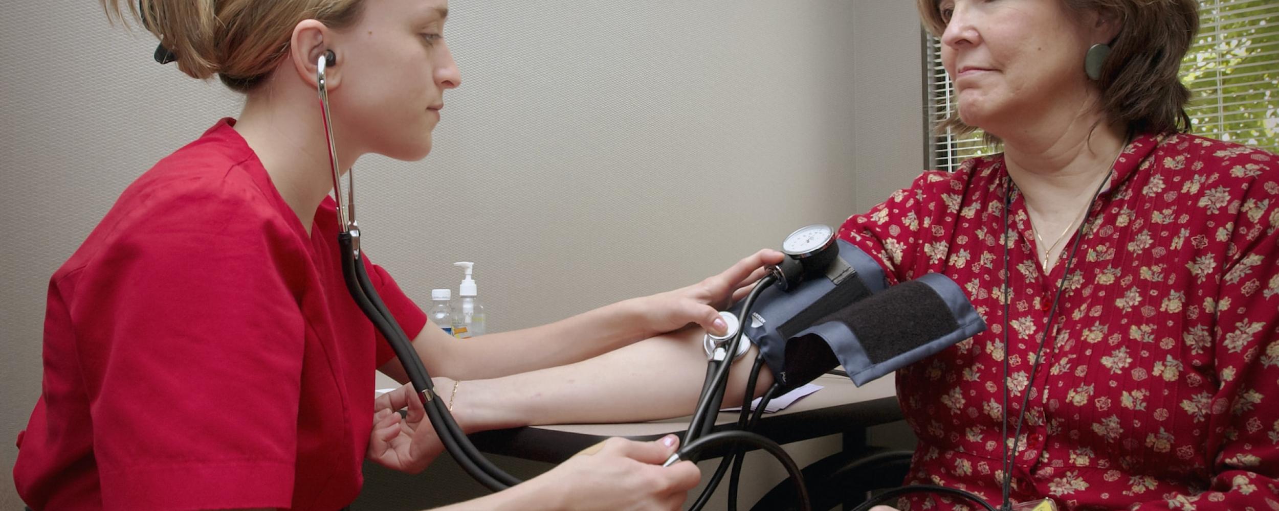 A doctor checking patient's blood pressure