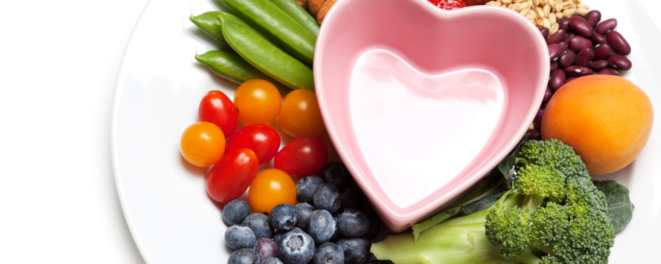 fruits, vegetables, grains, and protein on a plate around a heart-shaped bowl