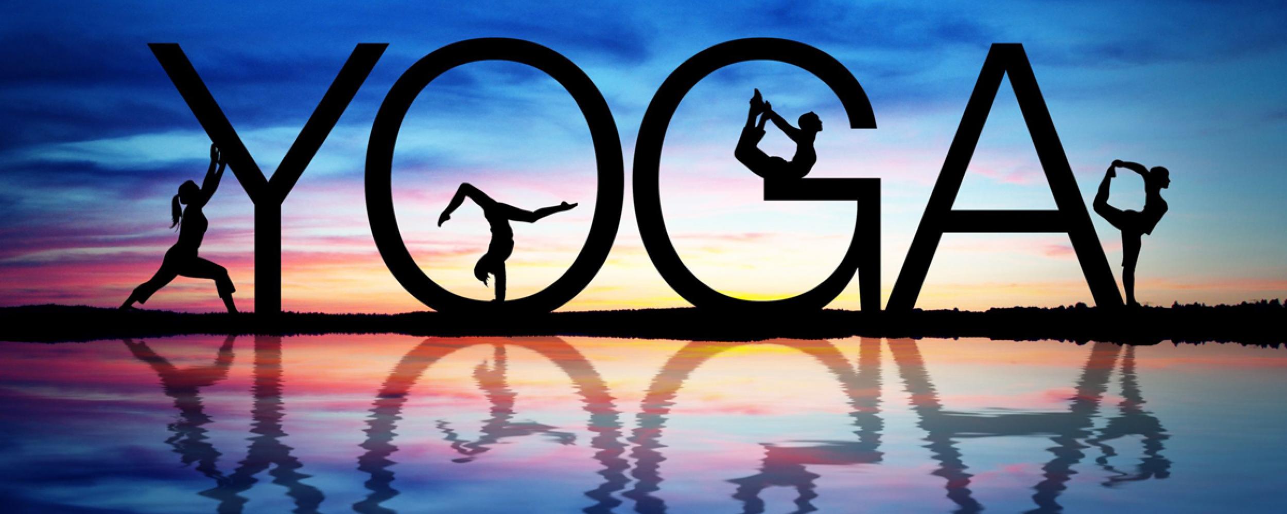 People doing yoga poses within and around letters that spell out Yoga with a sunset background.