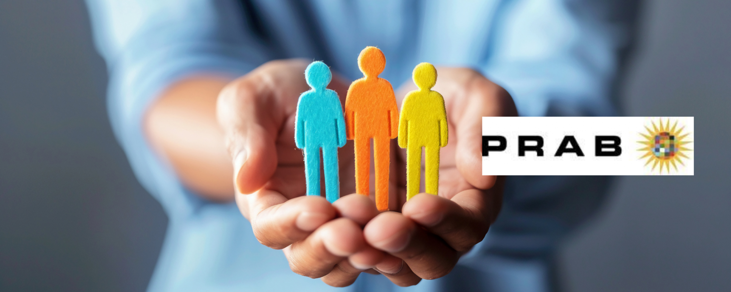 Hands stretched out holding paper cut-out of a family with the PRAB logo above
