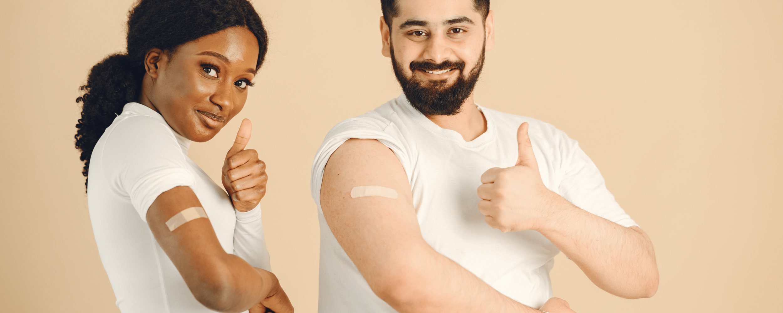 A young woman and a young man put a thumbs up after receiving a vaccine