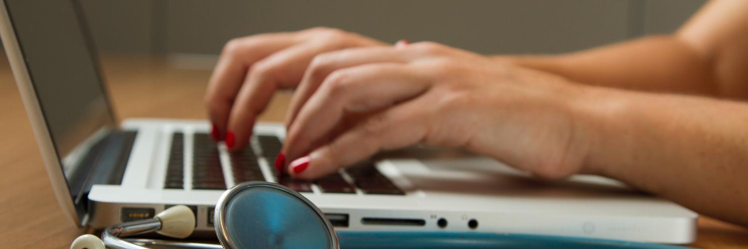 stethoscope next to a laptop