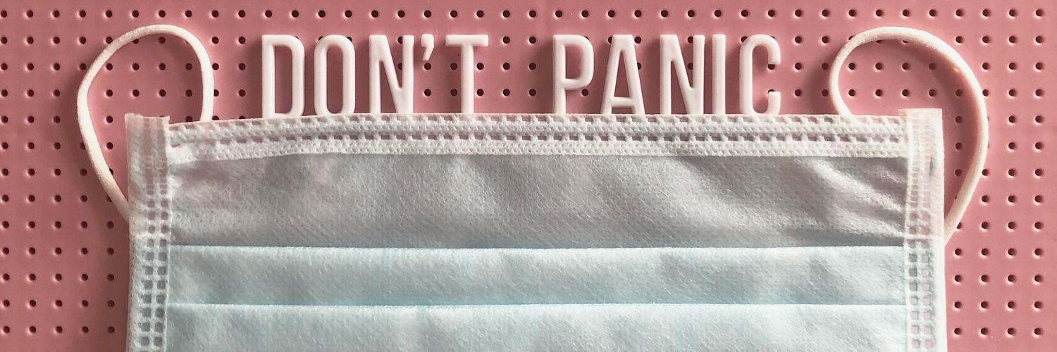 a face mask on a red background with the words "don't panic" written above the mask