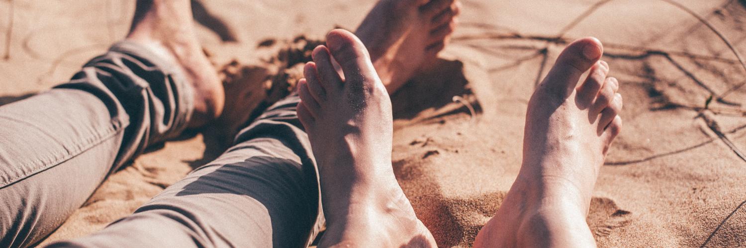 a picture of two people's feet on the sand