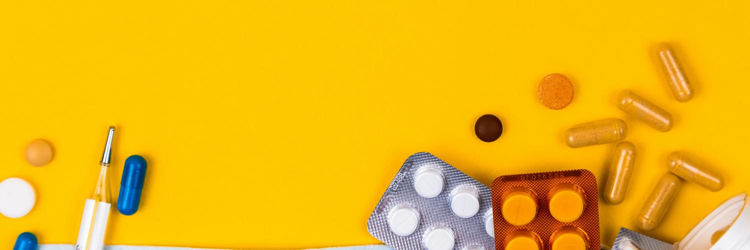 a pile of pills on top of a light blue face mask on a yellow background