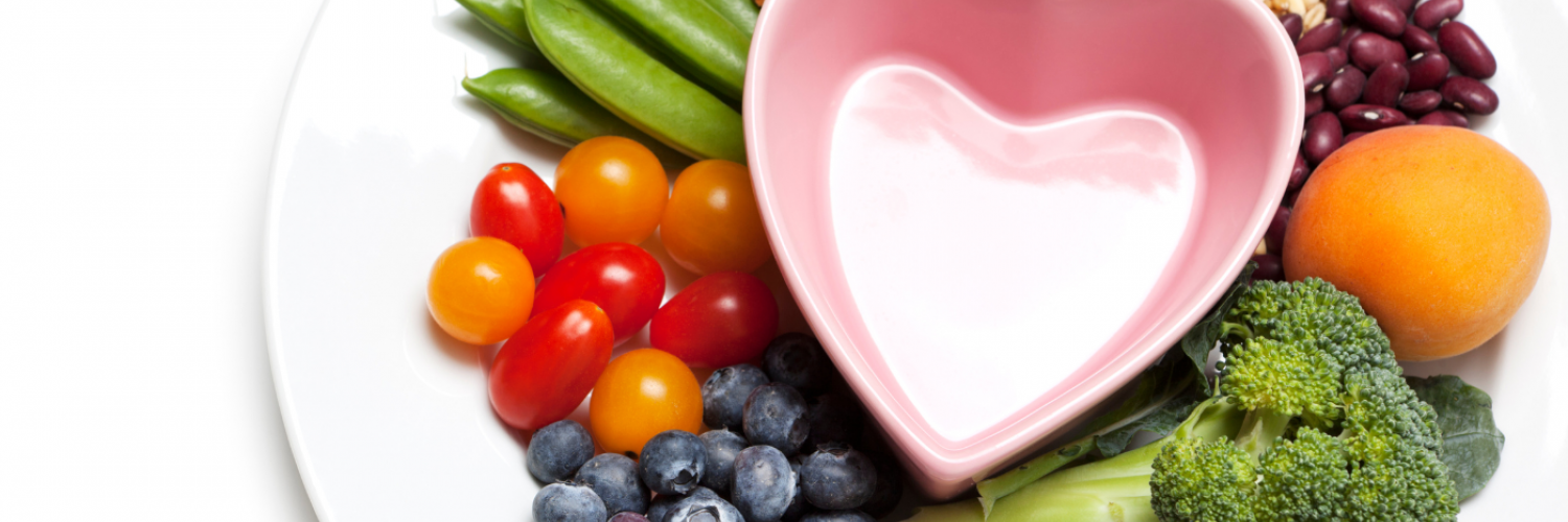 fruits, vegetables, grains, and protein on a plate around a heart-shaped bowl