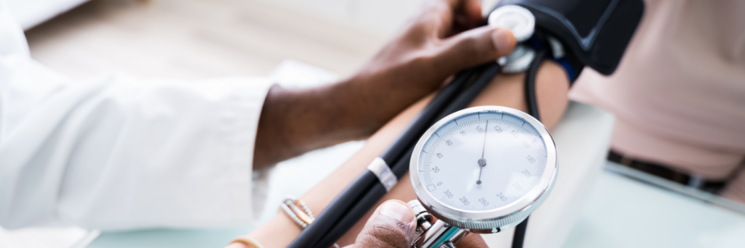 Doctor taking a patient’s blood pressure measurement with a sphygmomanometer