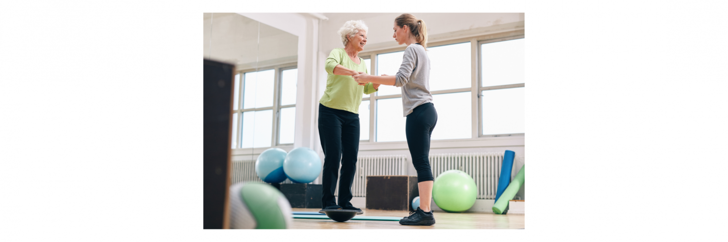 Female trainer helping senior adult woman in a gym exercising with a bosu balance training platform