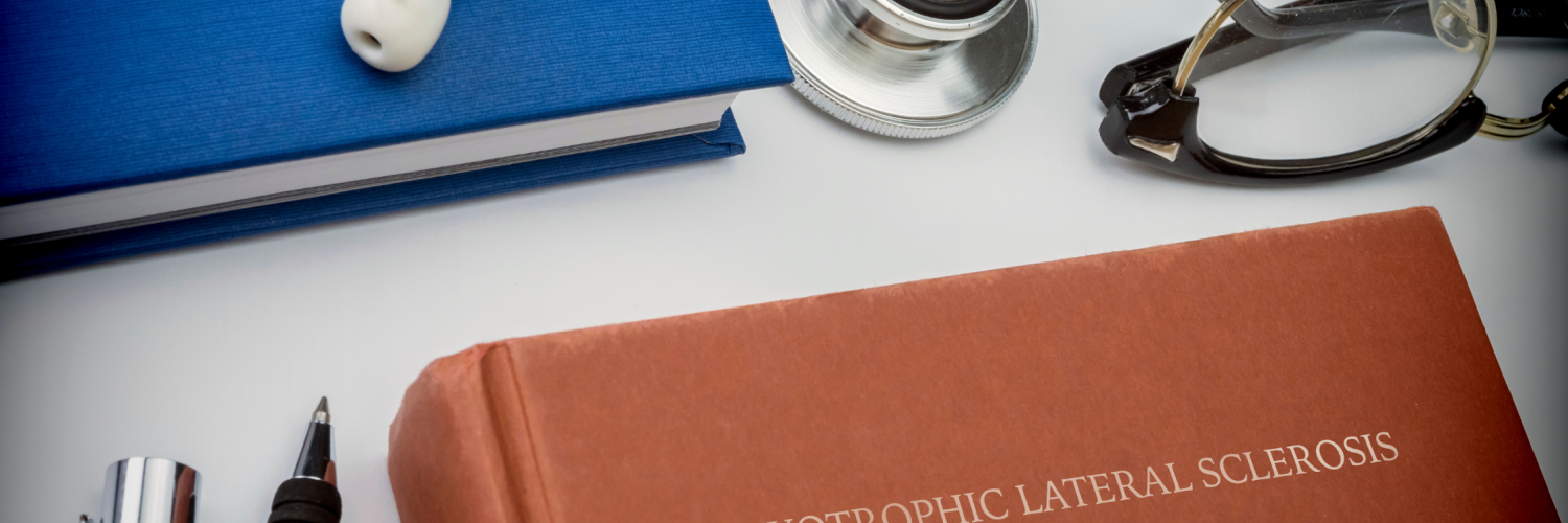 Conceptual image of a book entitled “Amyotrophic Lateral Sclerosis” alongside a stethoscope, eyeglasses, notebook, and writing utensils