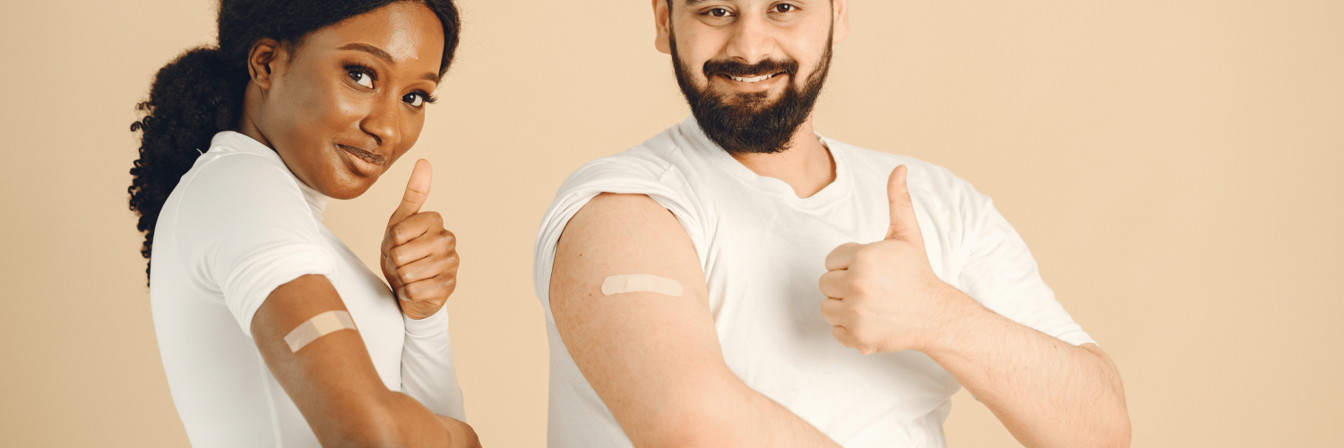 A young woman and a young man put a thumbs up after receiving a vaccine